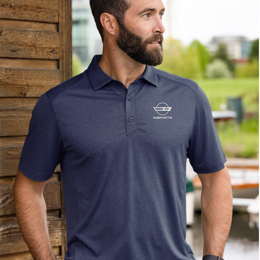 Man wearing a navy blue polo shirt with a C4 Corvette emblem, standing outdoors.