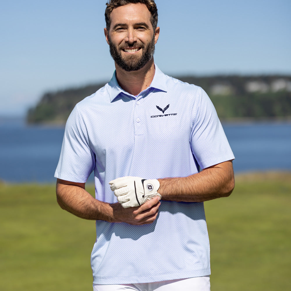 Man standing on a golf course wearing a diamond pattern polo with an embroidered C7 Corvette emblem on the left chest.