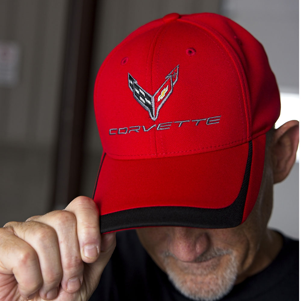 Man wearing the red cap with black trim on the bill with an embroidered C8 Corvette emblem on the front.