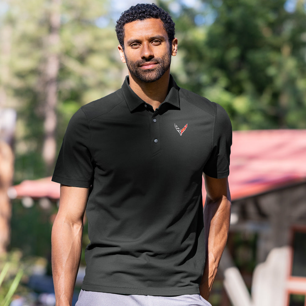 Man wearing a black polo shirt with a C8 Corvette emblem outdoors