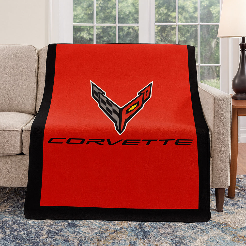Red Corvette blanket with a C8 Corvette logo on a couch in a living room