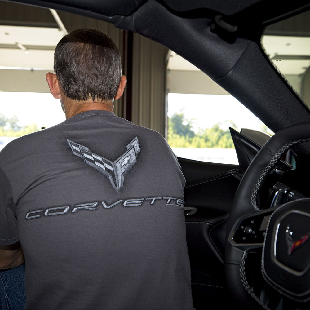 Man sitting in a car showing the back design with a large tonal gray C8 emblem on the back.