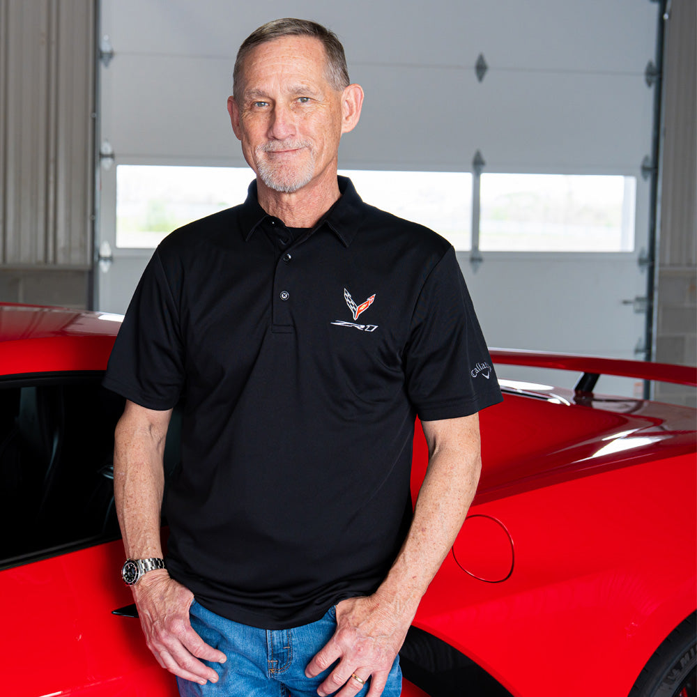 Man standing in front of a red Corvette wearing the 8th Generation ZR1 Corvette Black Polo