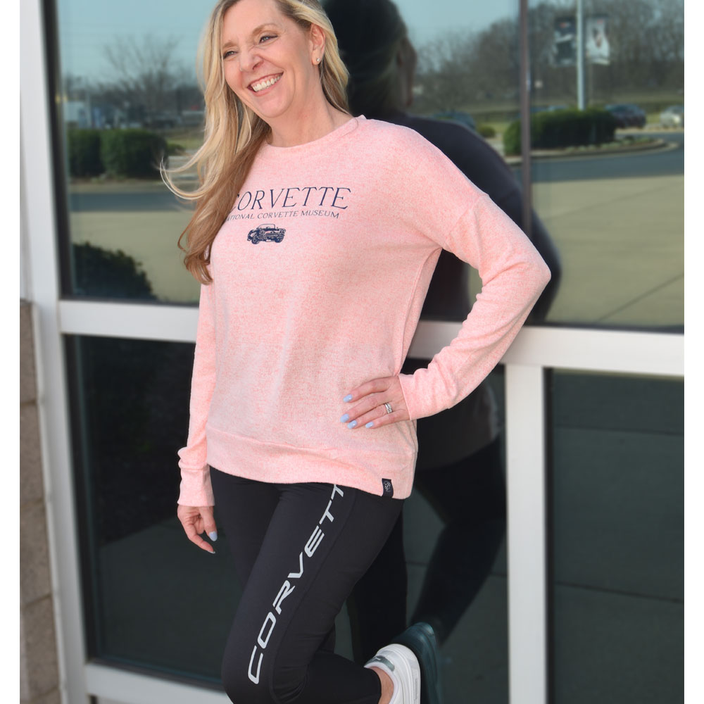 Woman wearing C1 Corvette Ladies Pink Crew Knit Pullover with black Corvette leggings