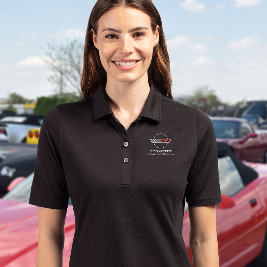 Woman wearing the C4 Corvette Emblem Ladies Core Black Virtue Polo