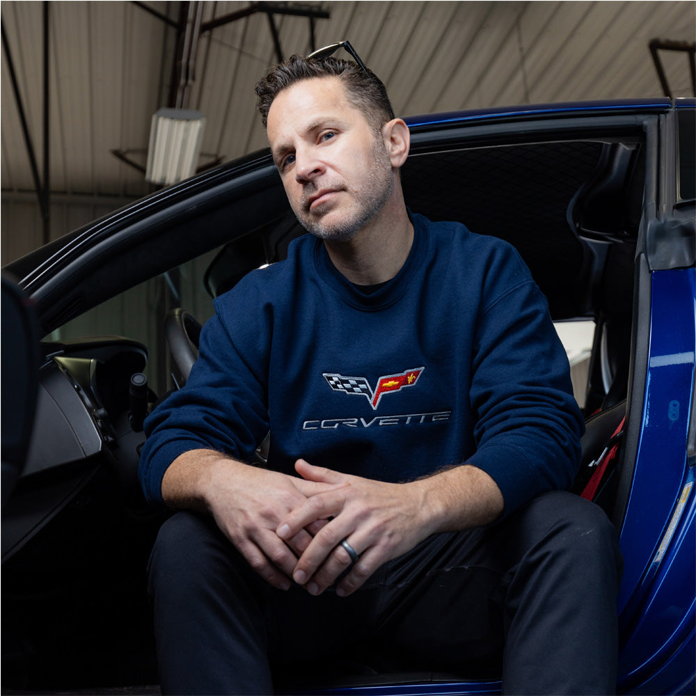 Man sitting in a Corvette wearing the C6 Corvette Embroidered Navy Sweatshirt