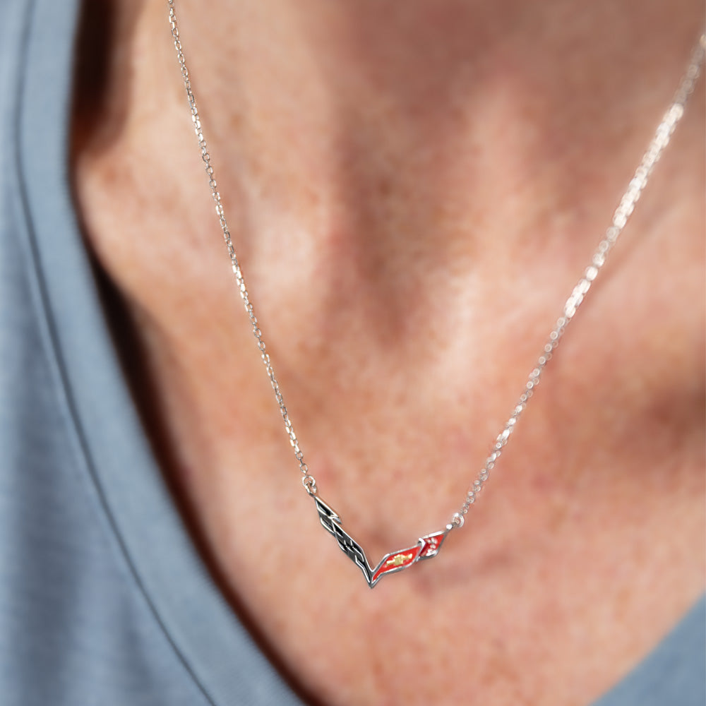 Necklace with a C7 Corvette emblem pendant worn by a woman