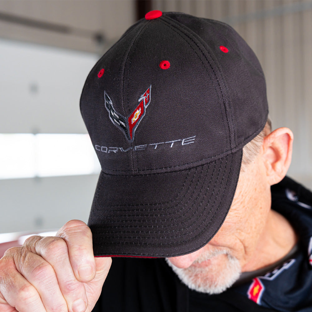 Person wearing a black C8 Corvette cap with logo and Corvette script.