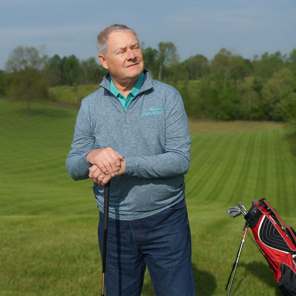 Man wearing the C8 Corvette Gesture Heather Navy Quarter-Zip Pullover while playing golf