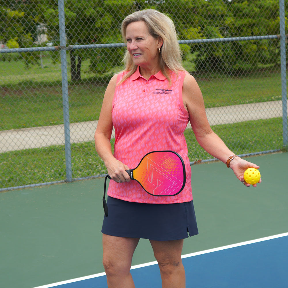 Woman wearing the C8 Corvette Gesture Ladies' Scribe Sleeveless Polo while playing pickleball