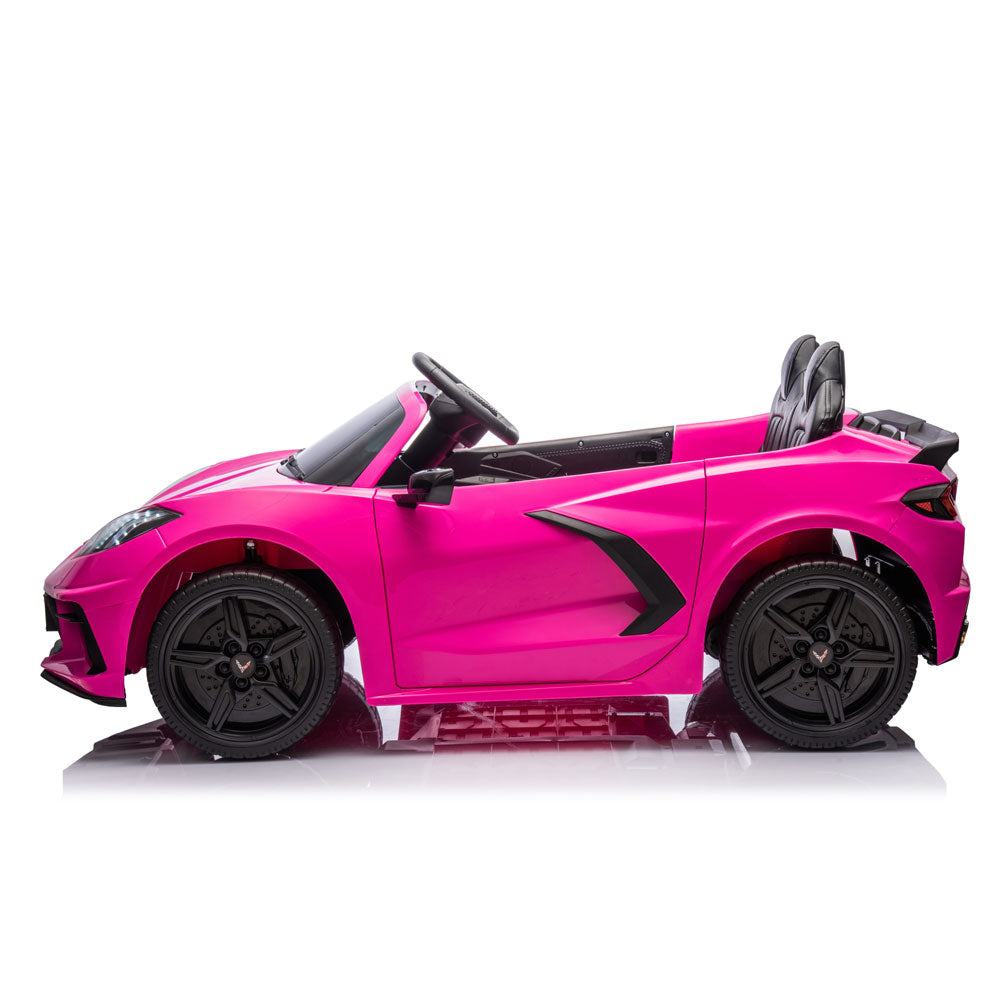 A bright pink Corvette convertible ride-on toy car with black wheels, black interior, and black side accents, shown in a side profile on a white background.