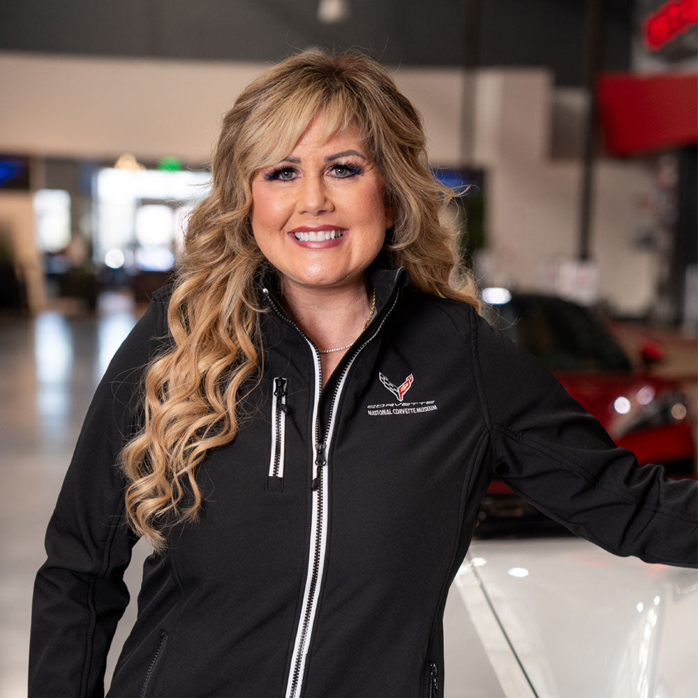 Lady wearing the C8 Corvette Ladies Telemark Black Jacket in the Corvette Museum Boulevard