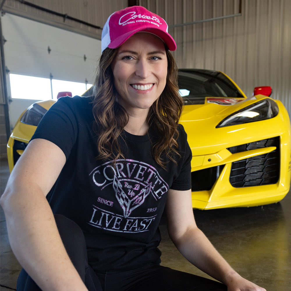 Woman sitting in front of a yellow Corvette wearing the C8 Corvette Live Fast Black Top
