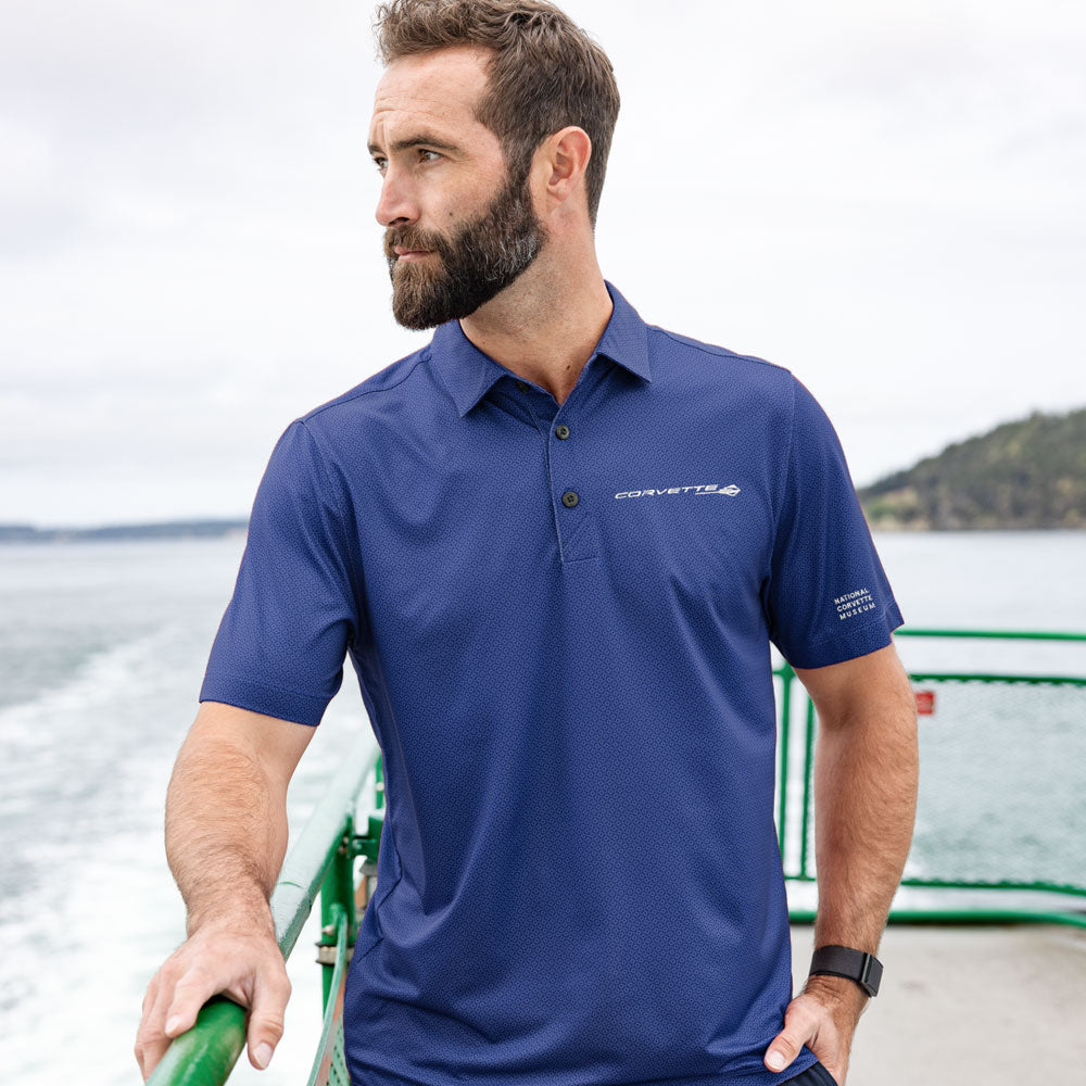 Man standing on the back of a barge wearing the C8 Corvette Stingray Geo Print Tour Blue Polo