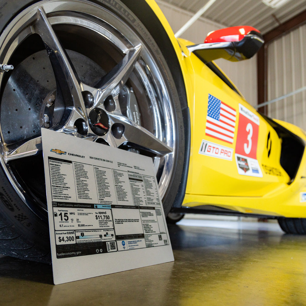 Corvette Aluminum Window Sticker shown leaning up against a C8 Corvette