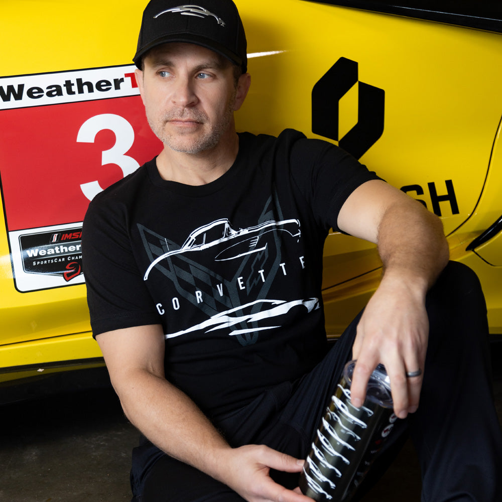 Man sitting by a Corvette wearing the Corvette Classic and Current Black Tee