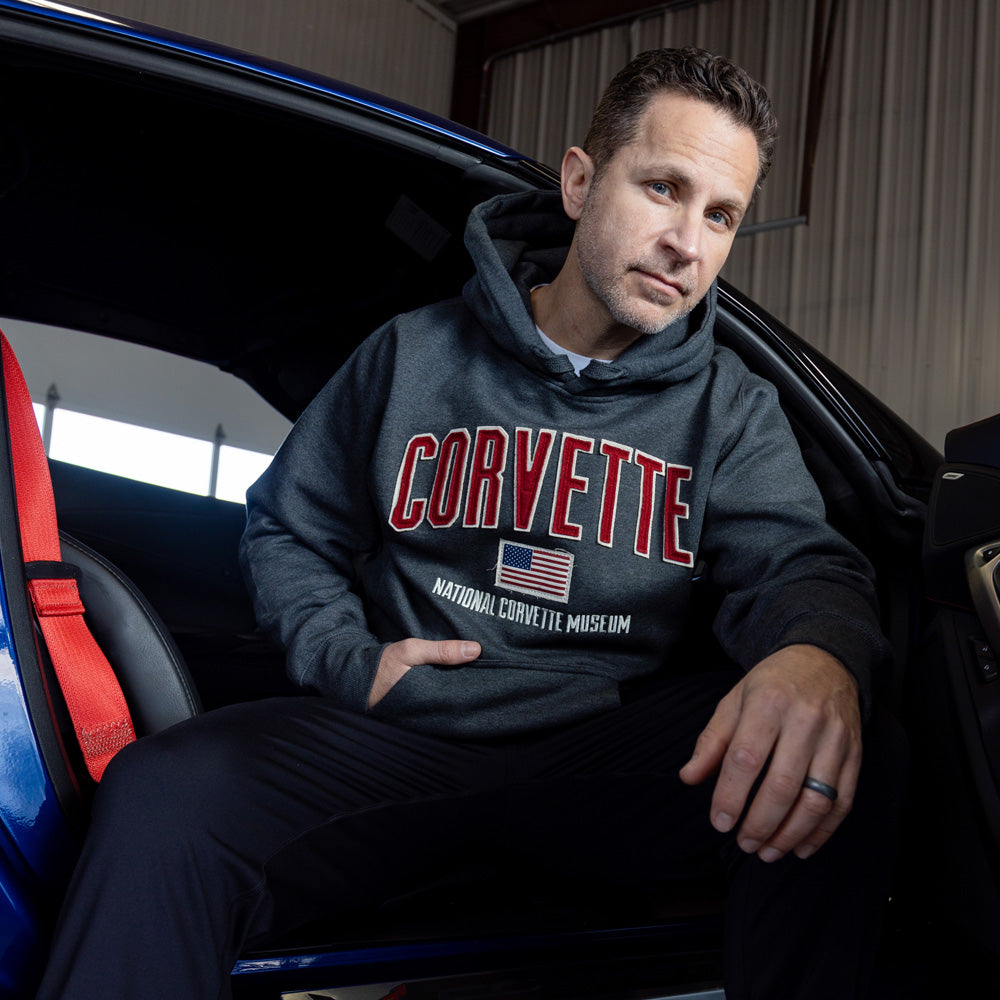 Man sitting in a Corvette wearing the Corvette Flag Justus Heavyweight Gray Sweatshirt
