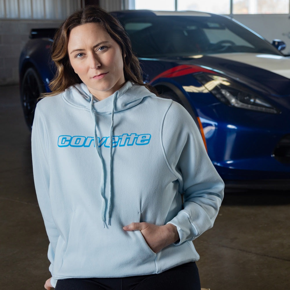 Woman sitting in front of a blue Corvette wearing the Corvette Ladies Icy Blue Hoodie