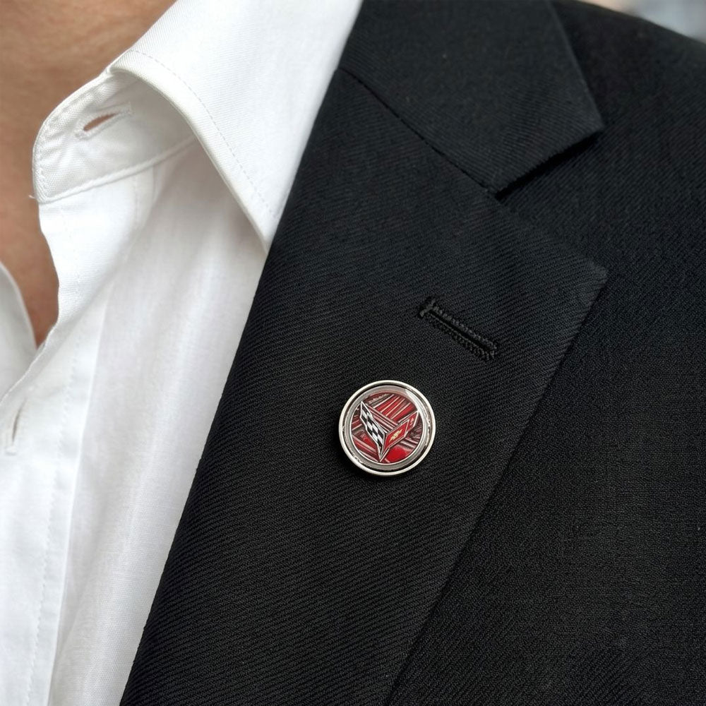 A close up of a person wearing the Corvette Paint C8 Corvette Lapel Pin on the lapel of their jacket.