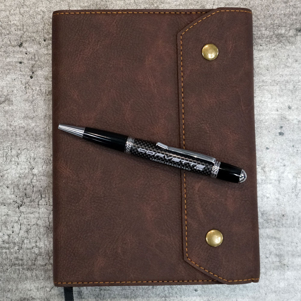Corvette Personalized Vin Carbon Fiber Material Pen shown on top of a leather padfolio