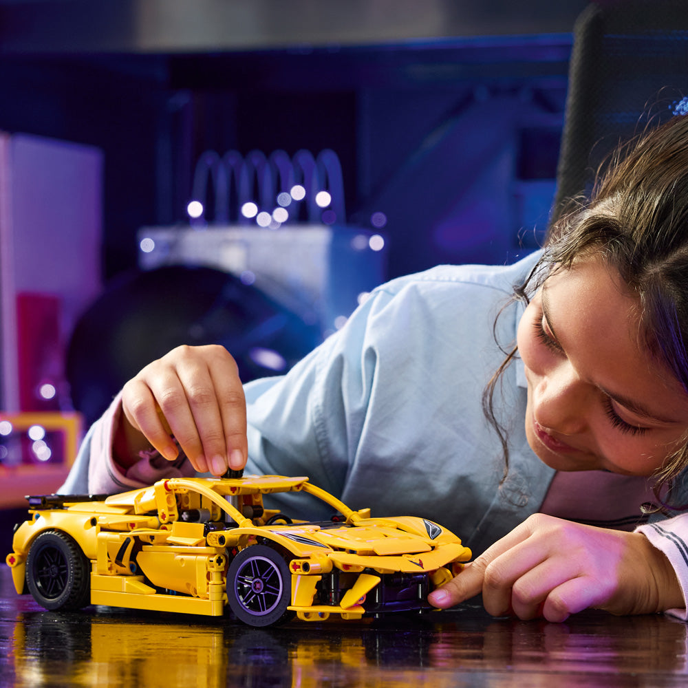 Child putting together the LEGO Technic Corvette Stingray C8 Toy Car Model Building Kit