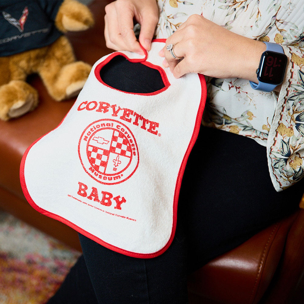Mother holding NCM Corvette Baby Bib on lap