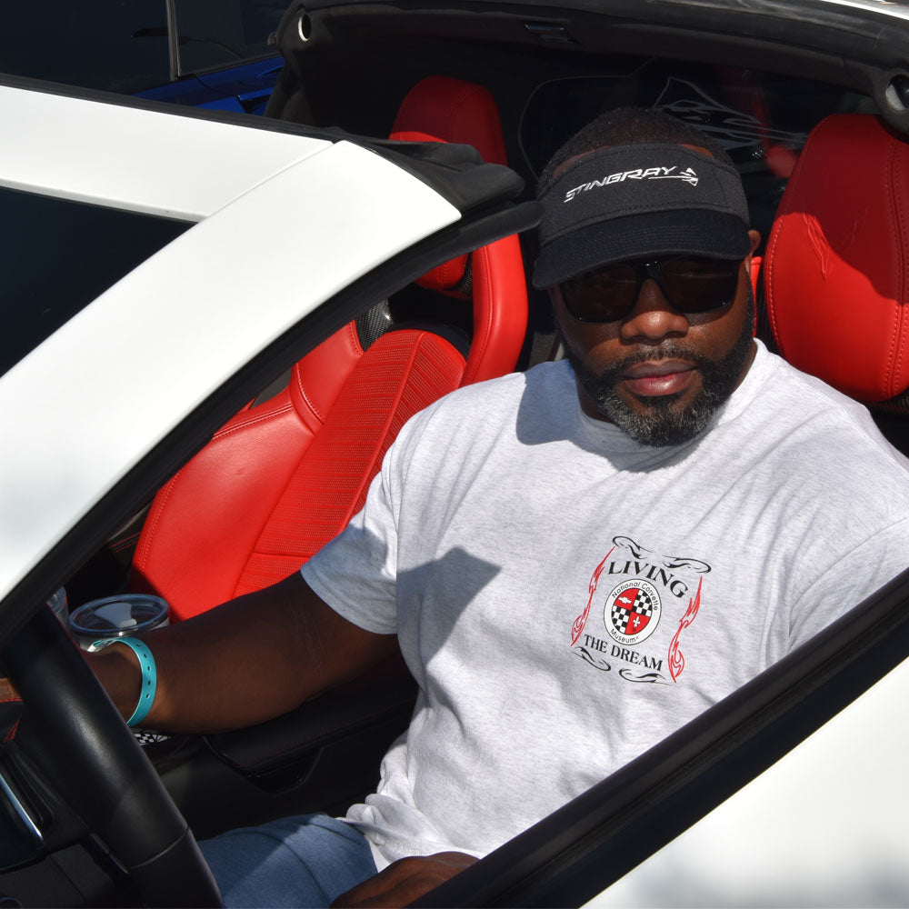 Man sitting in the car wearing the NCM Living the Dream Ash Gray T-shirt