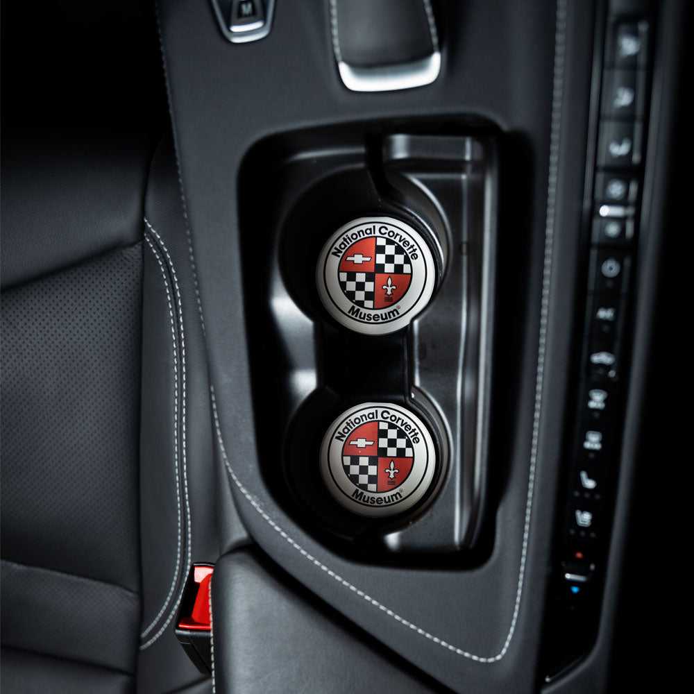 NCM Logo Car Coasters shown in the cupholders inside a Corvette