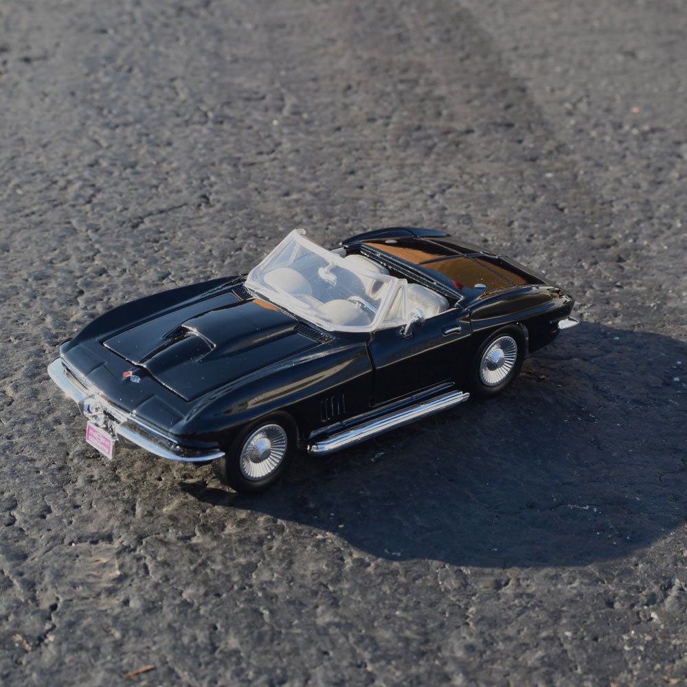 1967 Corvette Black Diecast Model shown in a road setting