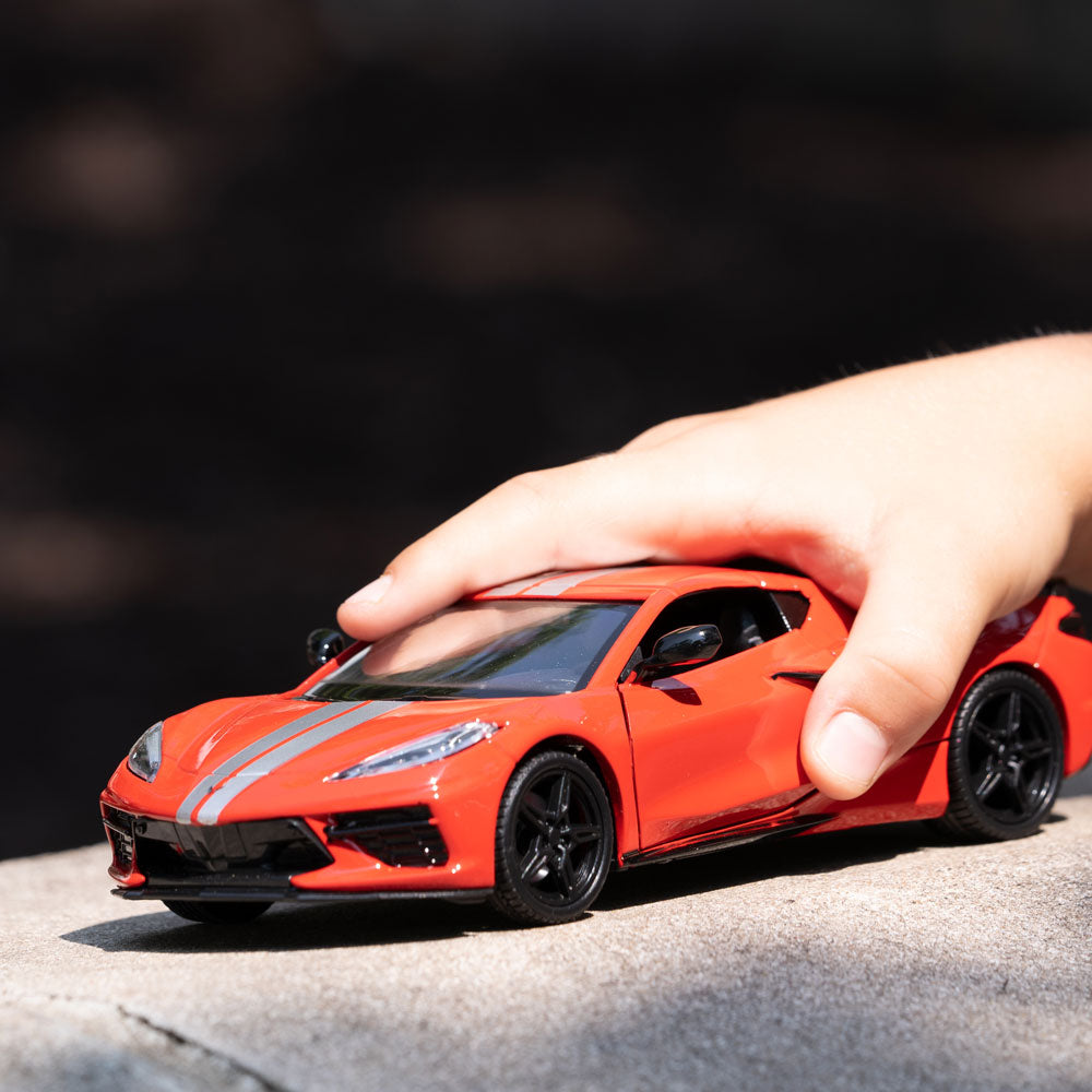 Boy playing with the 2020 Corvette Torch Red and Silver Diecast Model