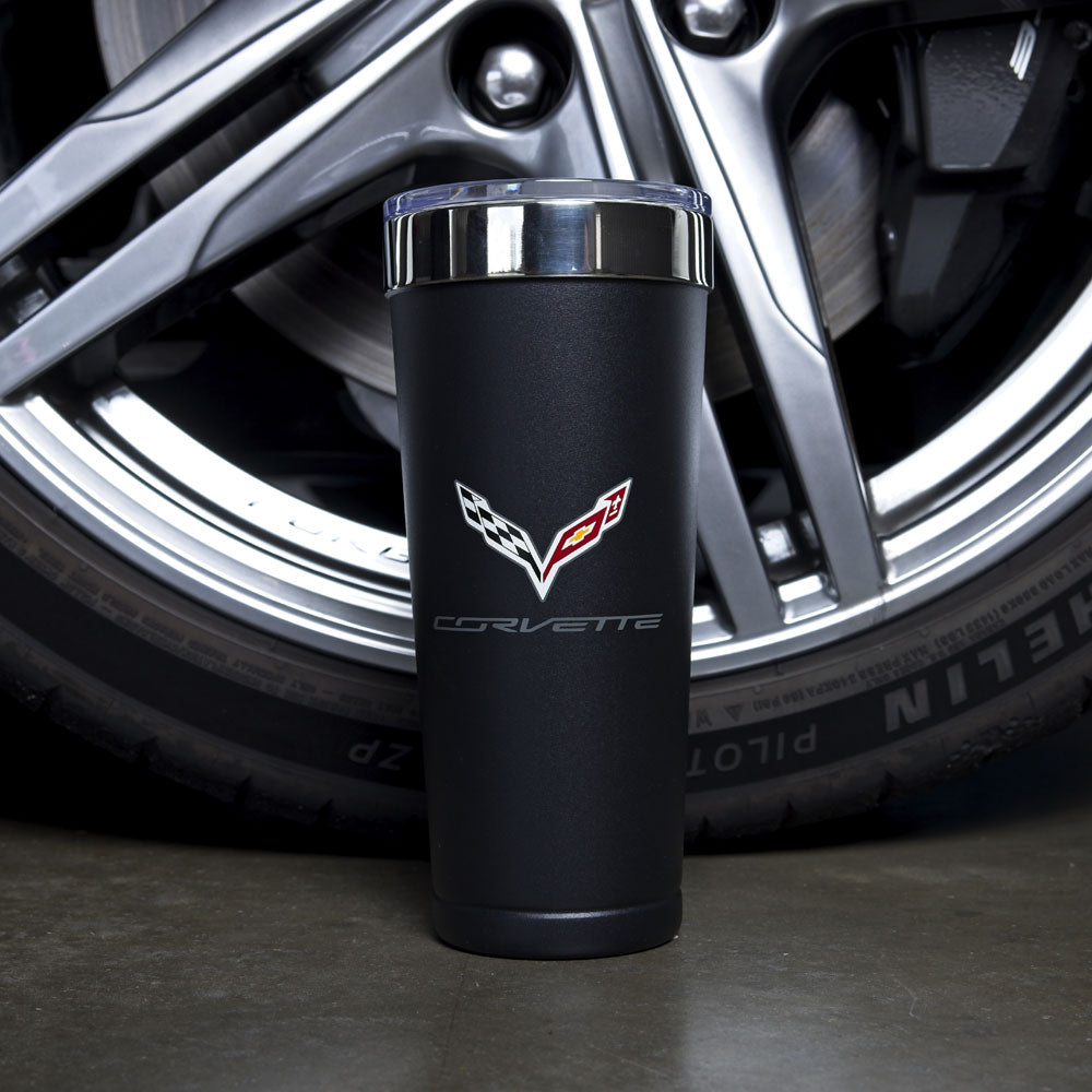 The 7th Generation Corvette Emblem Polar Tumbler shown displayed in front of the tire of a Corvette.
