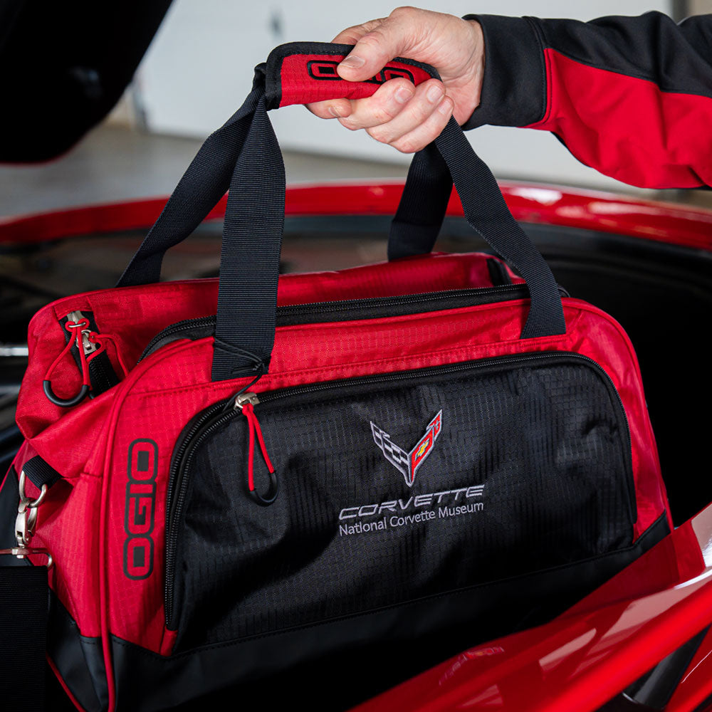A man pulling the 8th Generation Corvette Duffle Bag out of the trunk of his Corvette.