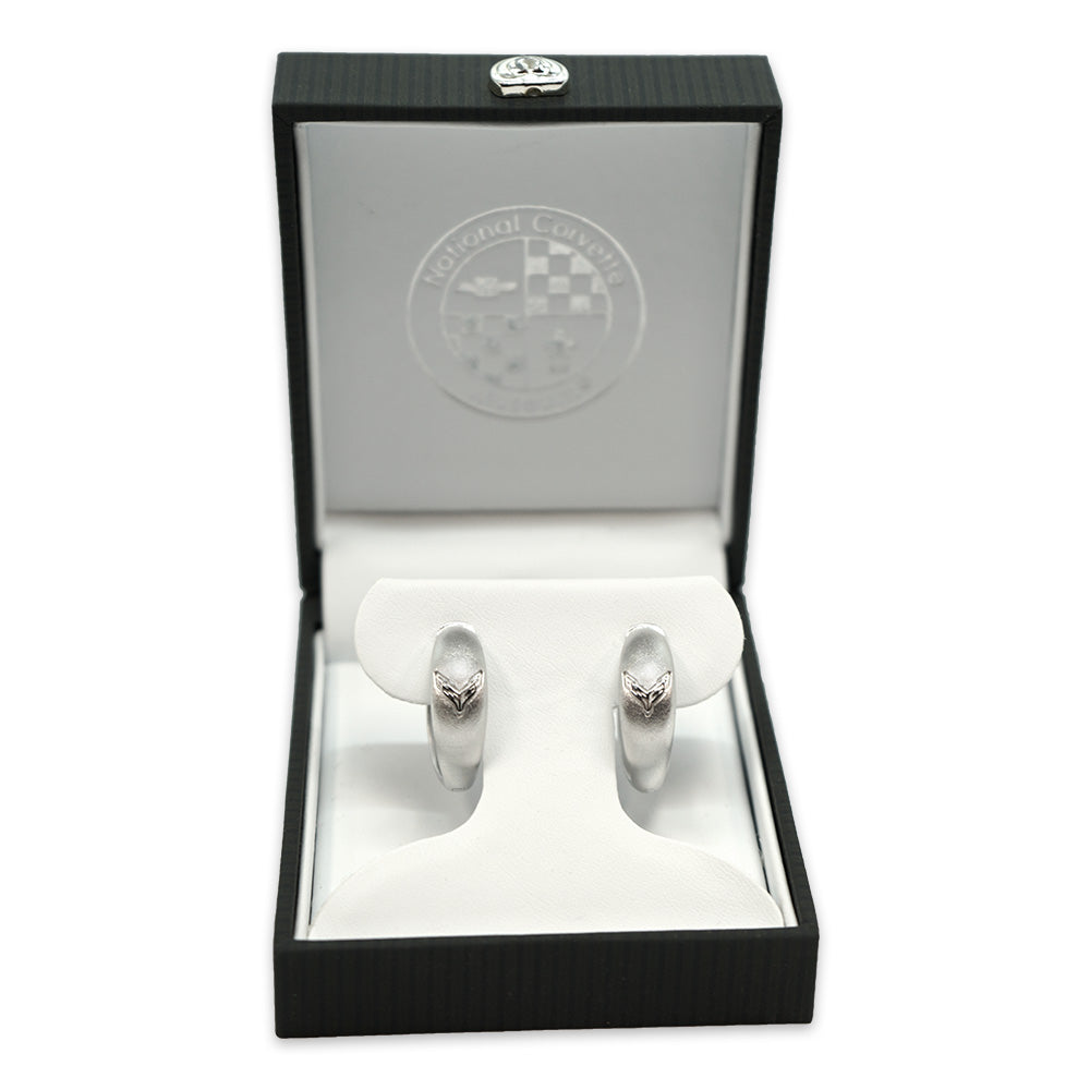 The 8th Generation Corvette Emblem Sterling Silver Huggie Earrings shown in a gift box on a white background