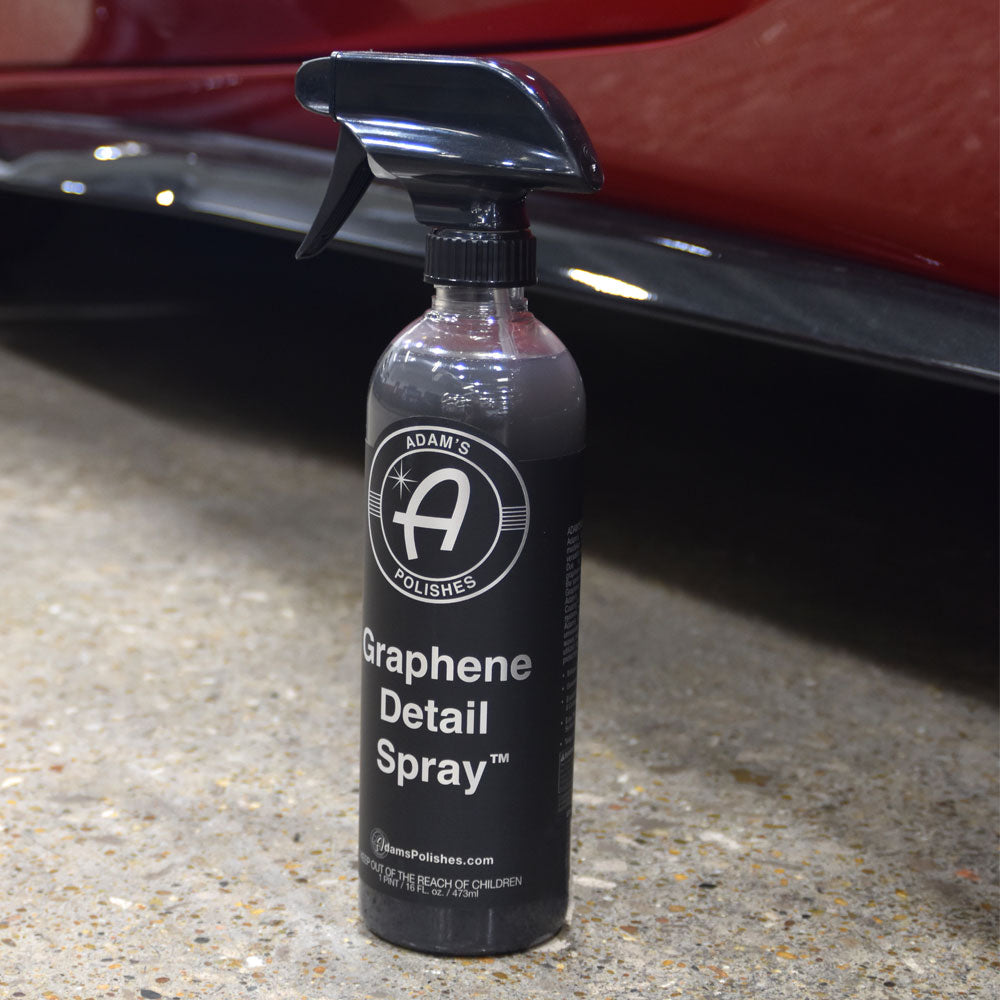 Adams Graphene Detail Spray placed on the garage floor next to a Corvette