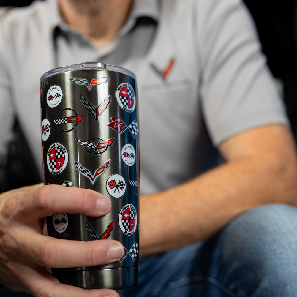 Man sitting in a Corvette holding the C1-C8 Corvette Emblems Graphite Travel Mug