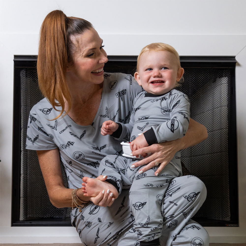 Toddler sitting on his moms lap wearing the C1 through C8 Corvette Emblems Print Toddler Pajama Set