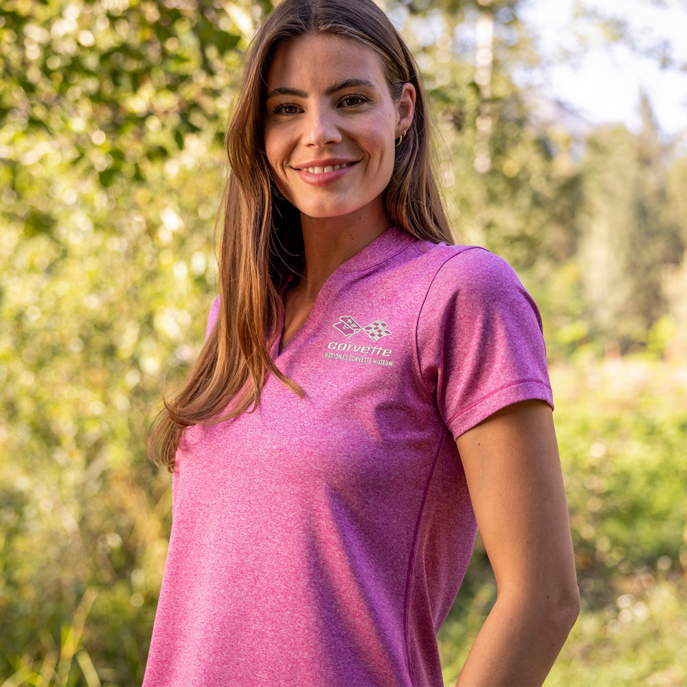 Woman standing in a park wearing the Heather Raspberry C3 Corvette Custom Ladies No Collar V-Neck Polo