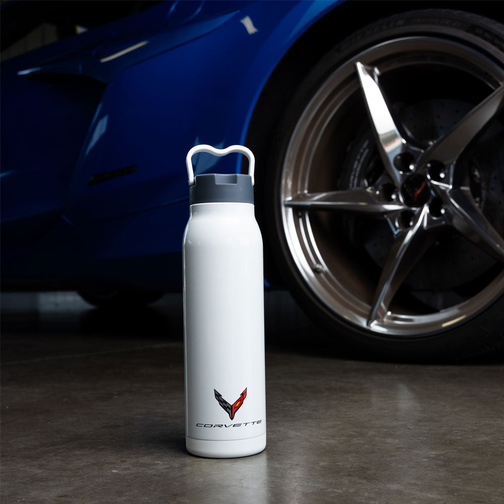 C8 Corvette 32oz White Water Bottle shown on the ground in front of the wheel of a C8 Corvette