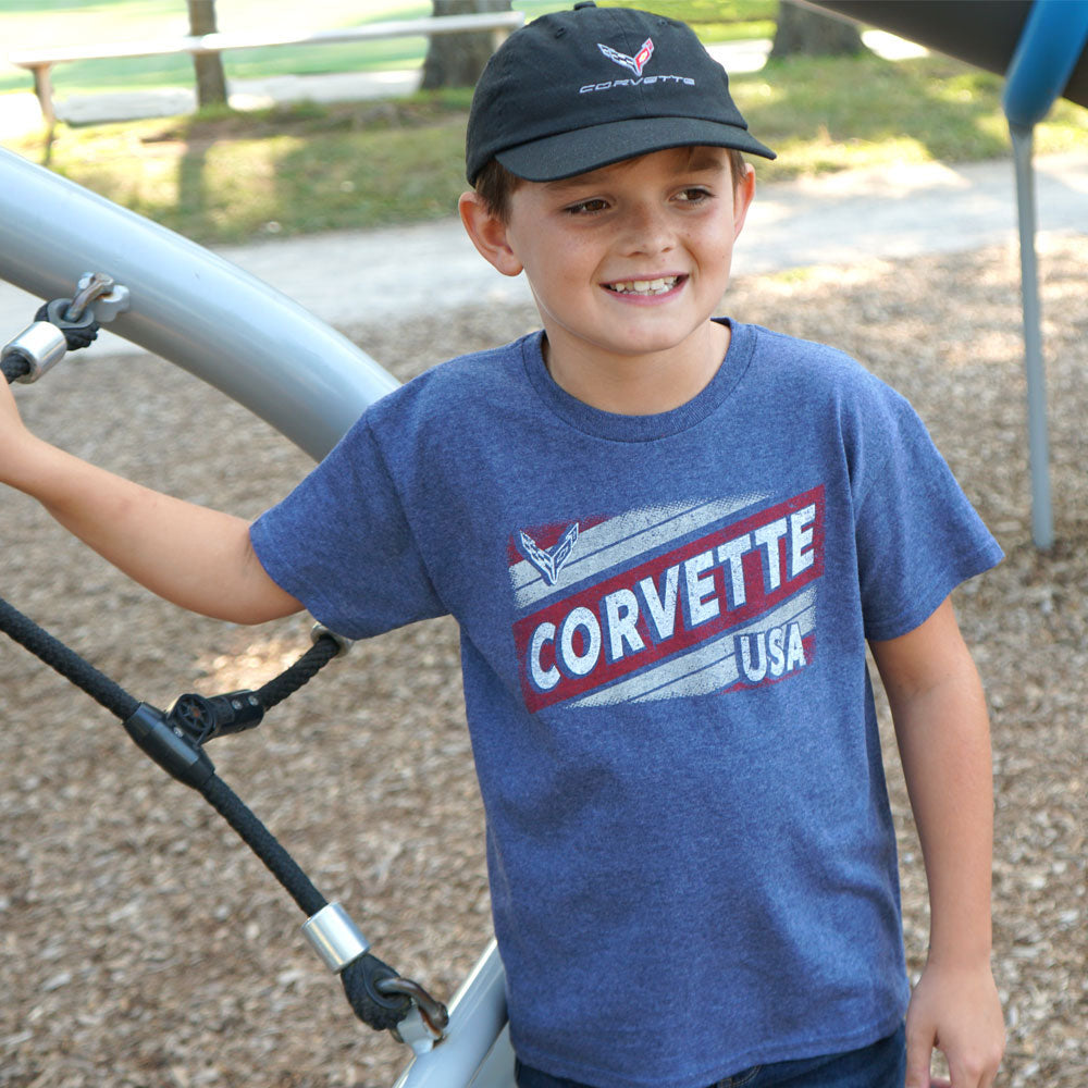 Boy playing on a playground wearing the C8 Corvette Emblem Childrens Black Cap