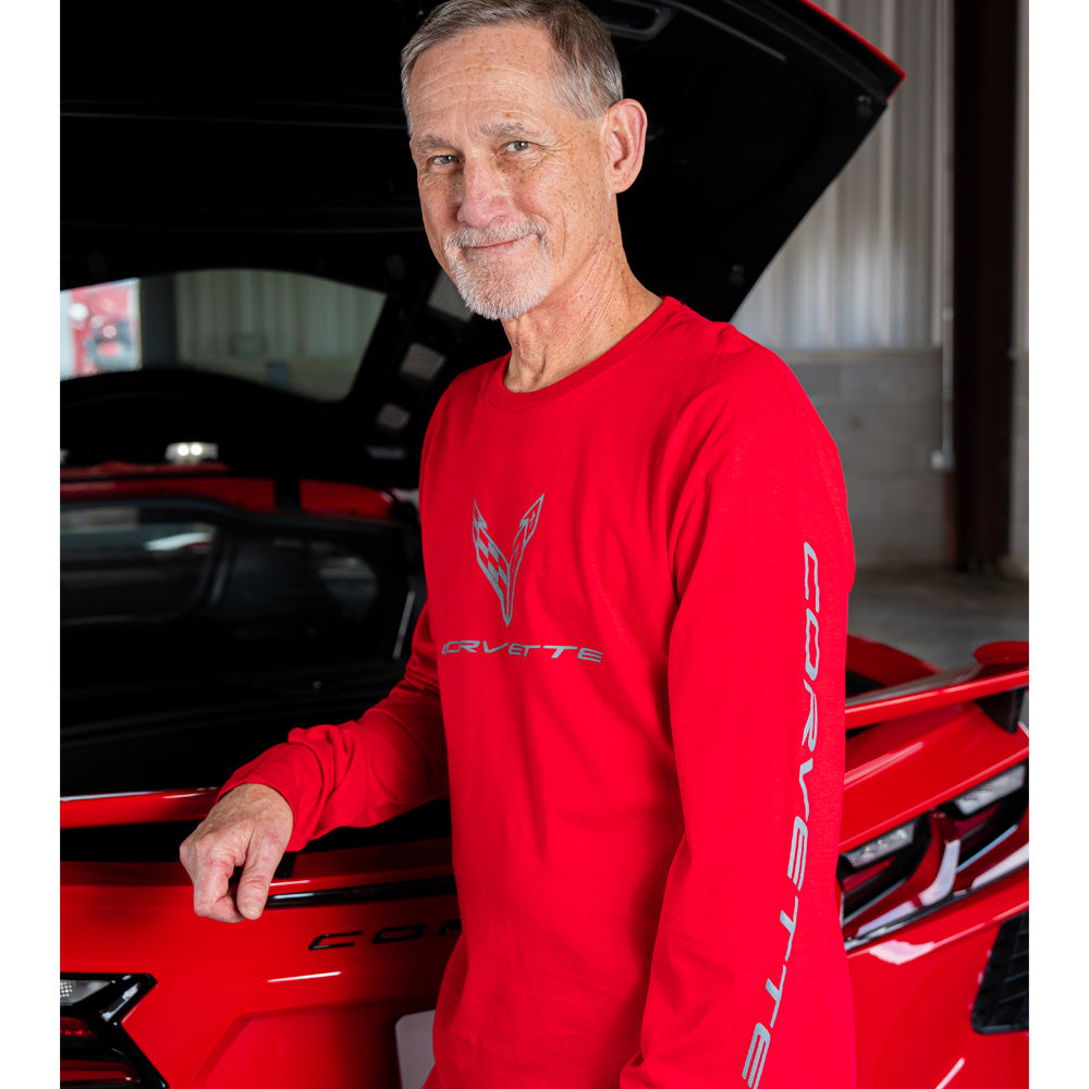Man in a red C8 Corvette long sleeve t-shirt standing next to a red Corvette with an open hood.