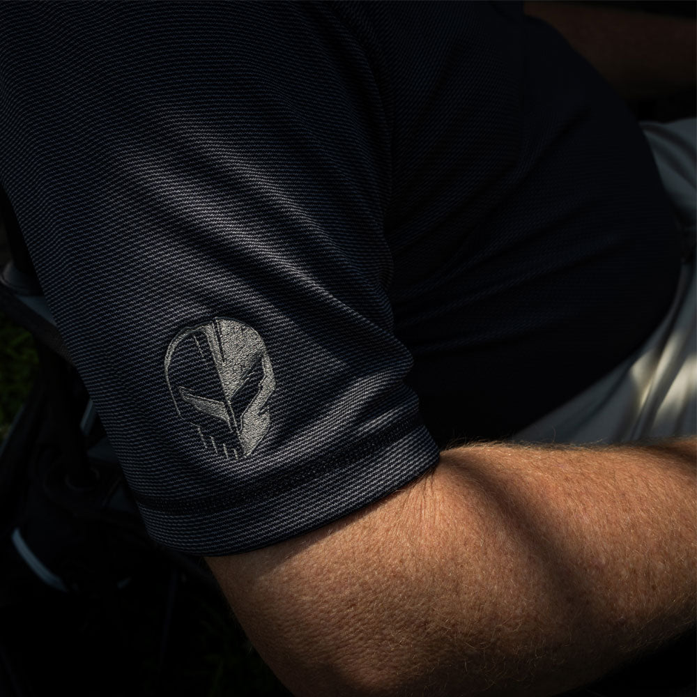 Close up of the Jake logo embroidered on the C8 Corvette Racing Pebble Beach Polo Sleeve