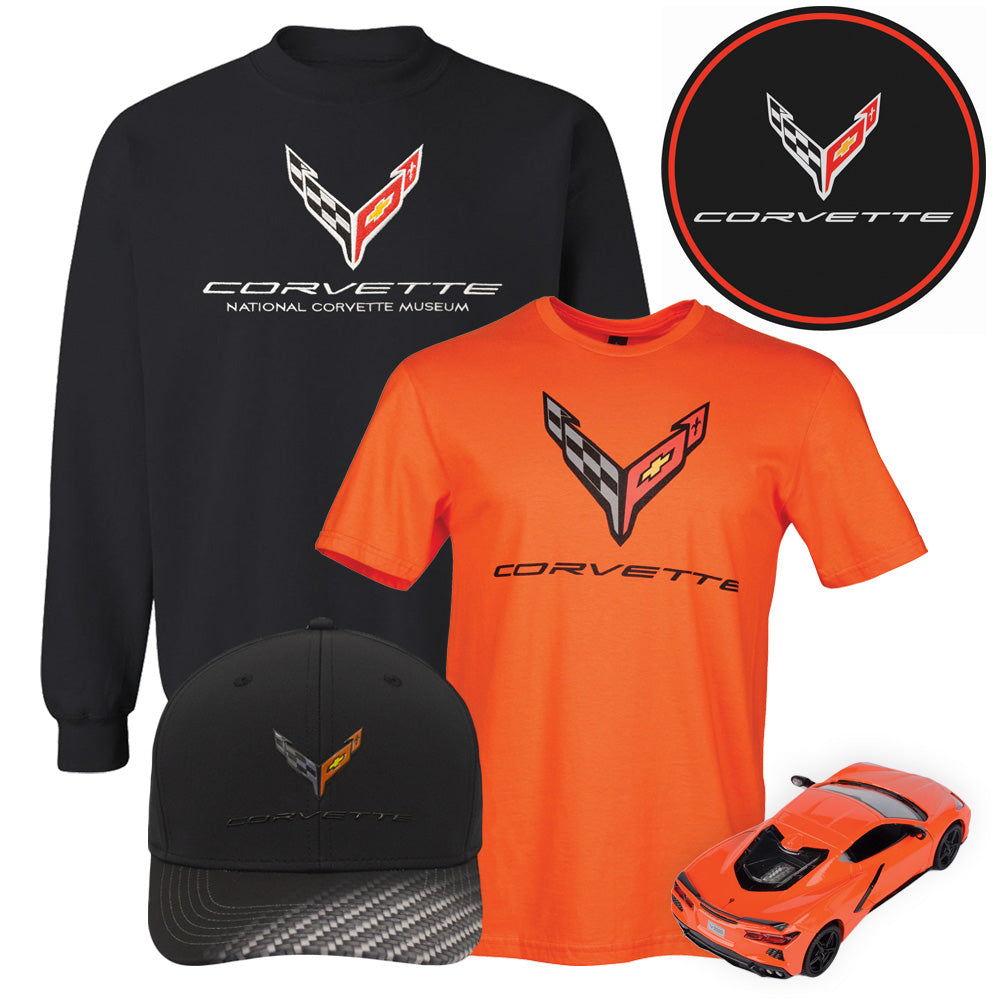 Gift bundle showing a C8 black sweatshirt, a C8 orange tee, a round black C8 emblem tin sign, a black C8 cap and an orange C8 diecast model