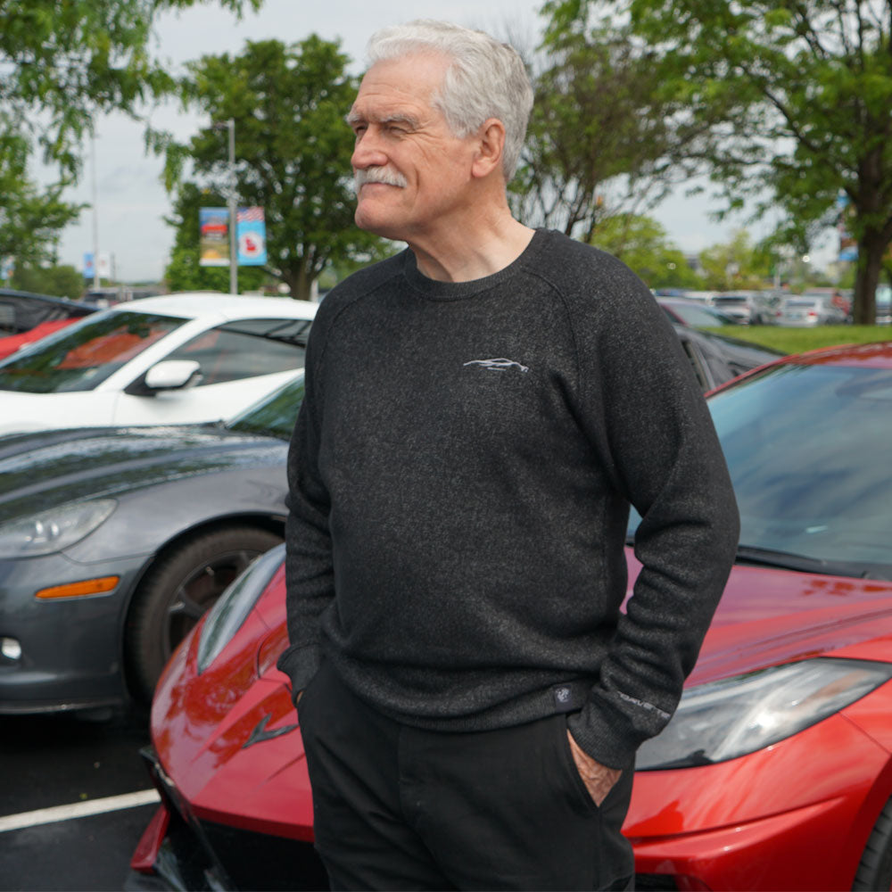 Man wearing the C8 Gesture Charcoal Gray Raglan Crew Pullover standing in front of a red Corvette