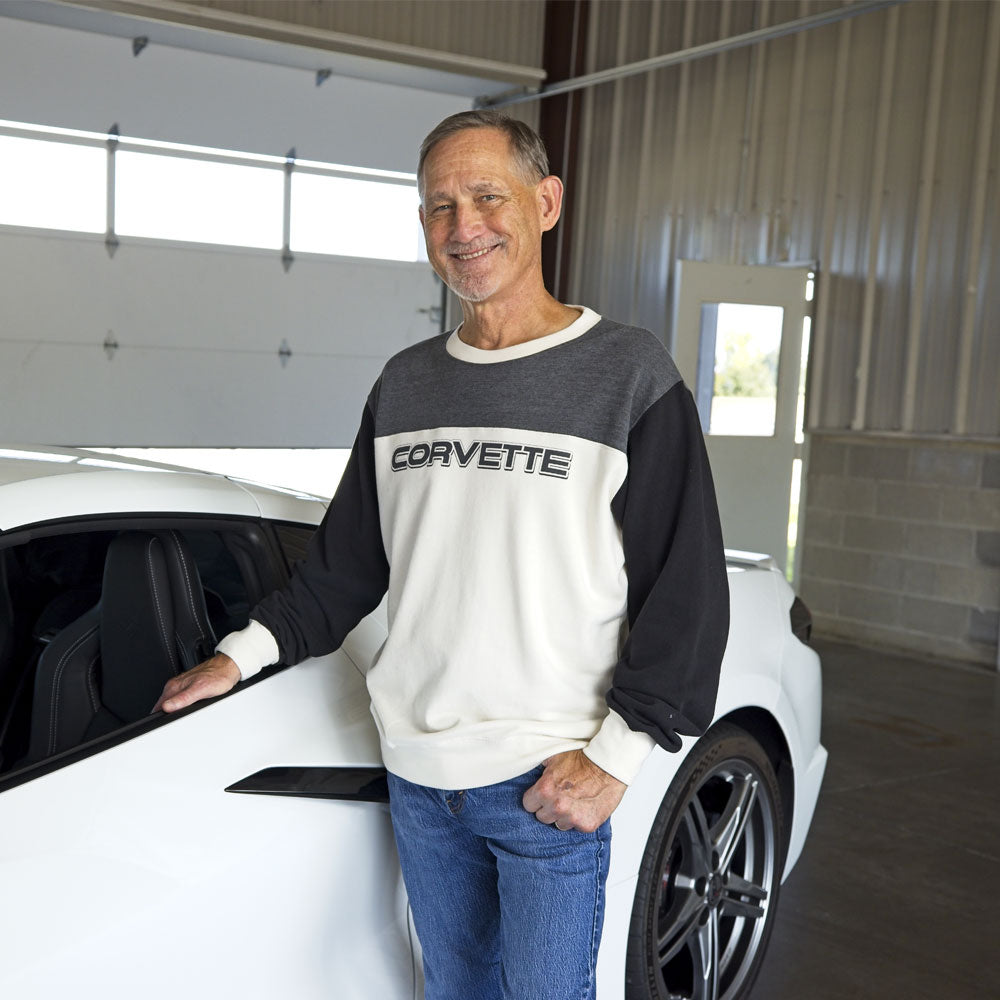 Man standing in front of a White Corvette wearing the Corvette Colorblock Crewneck Sweatshirt.