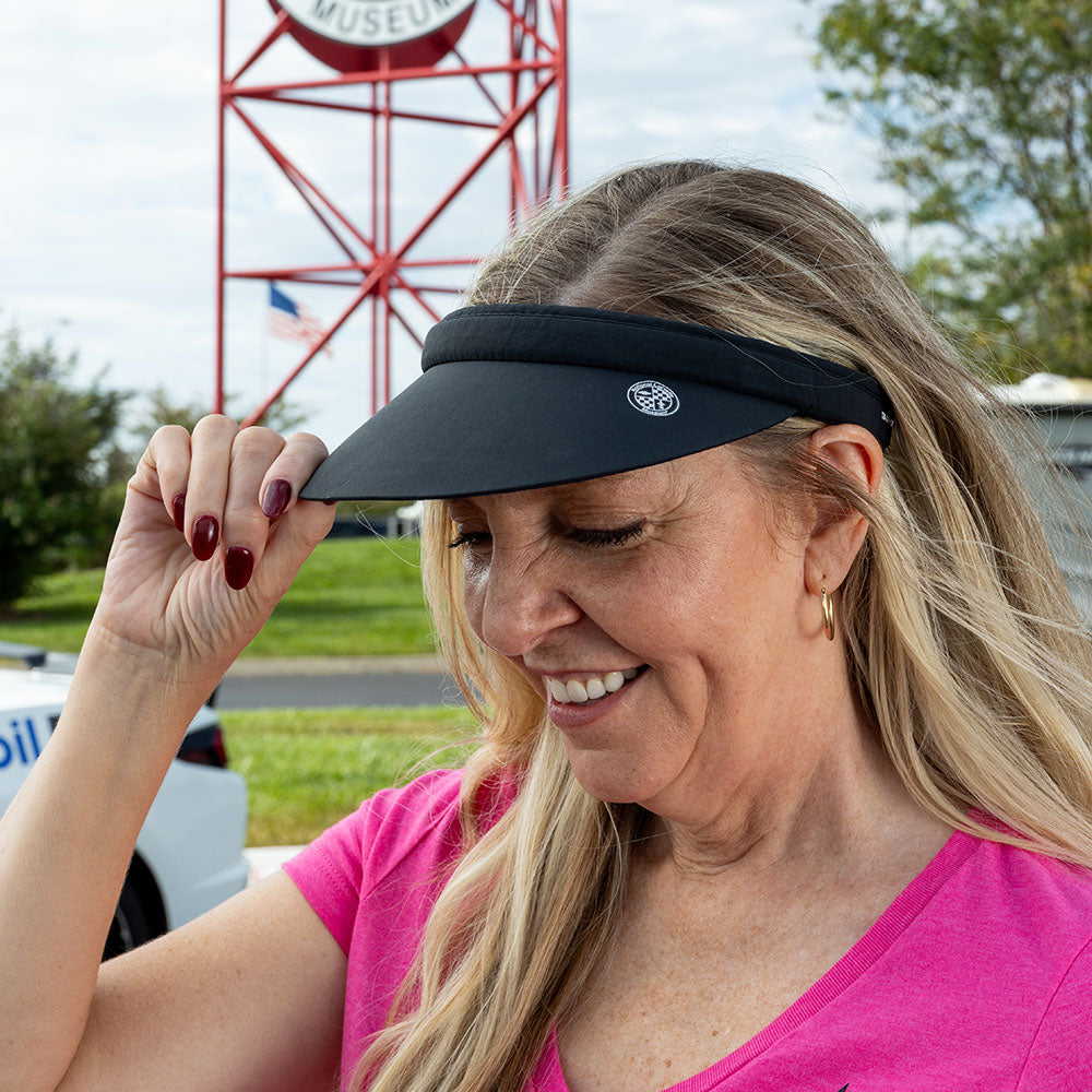 Woman wearing the Corvette Crystal Clip-On Black Visor showing the close up of the National Corvette Museum emblem