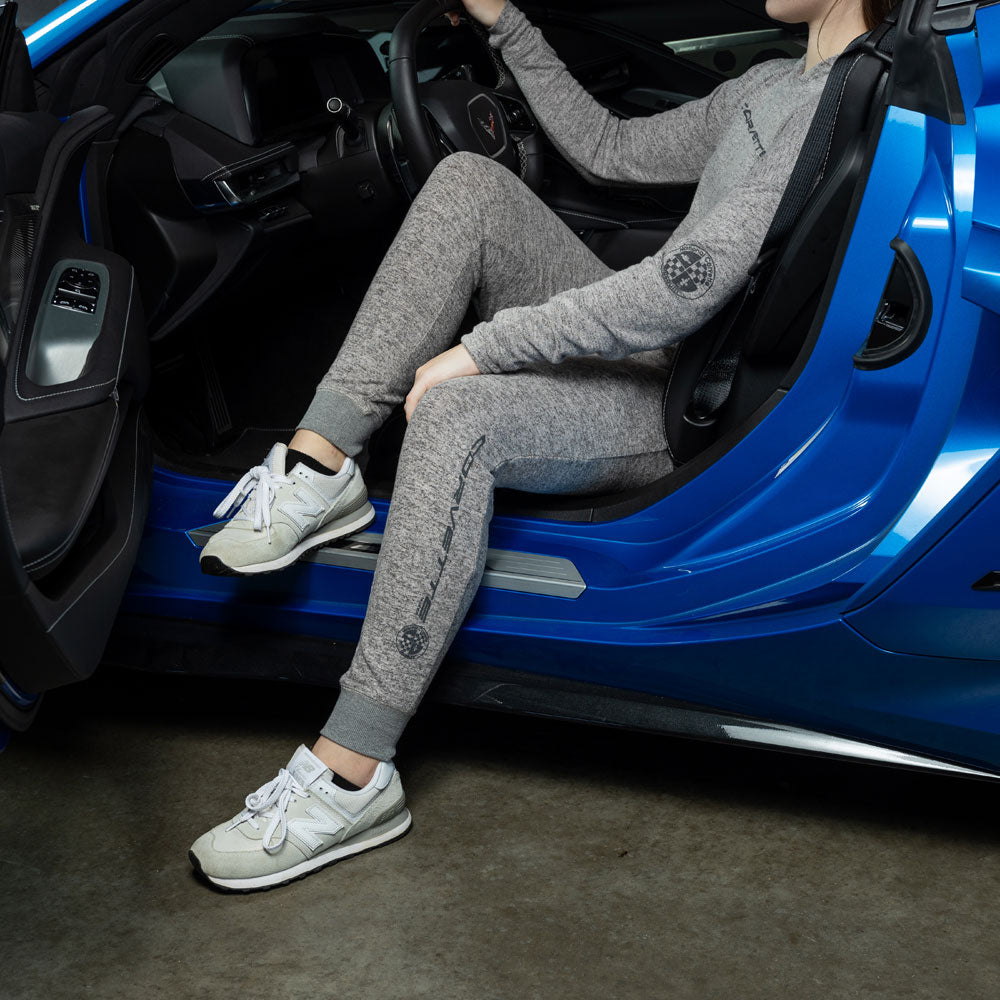 Woman sitting in the driver seat of a blue Corvette wearing the Corvette Ladies Charcoal Lounge Jogger Pants 