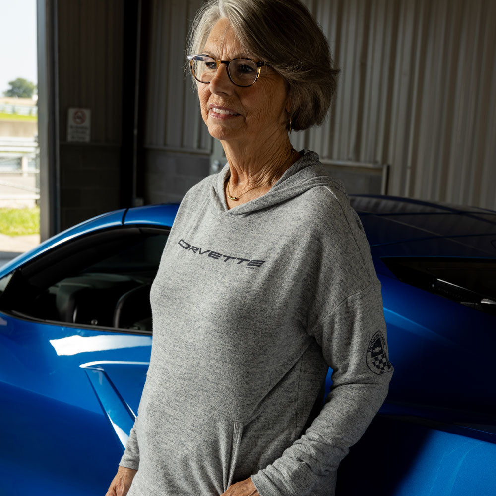 Woman standing in front of a blue Corvette wearing the Corvette Ladies' Navy Loungewear Hoodie