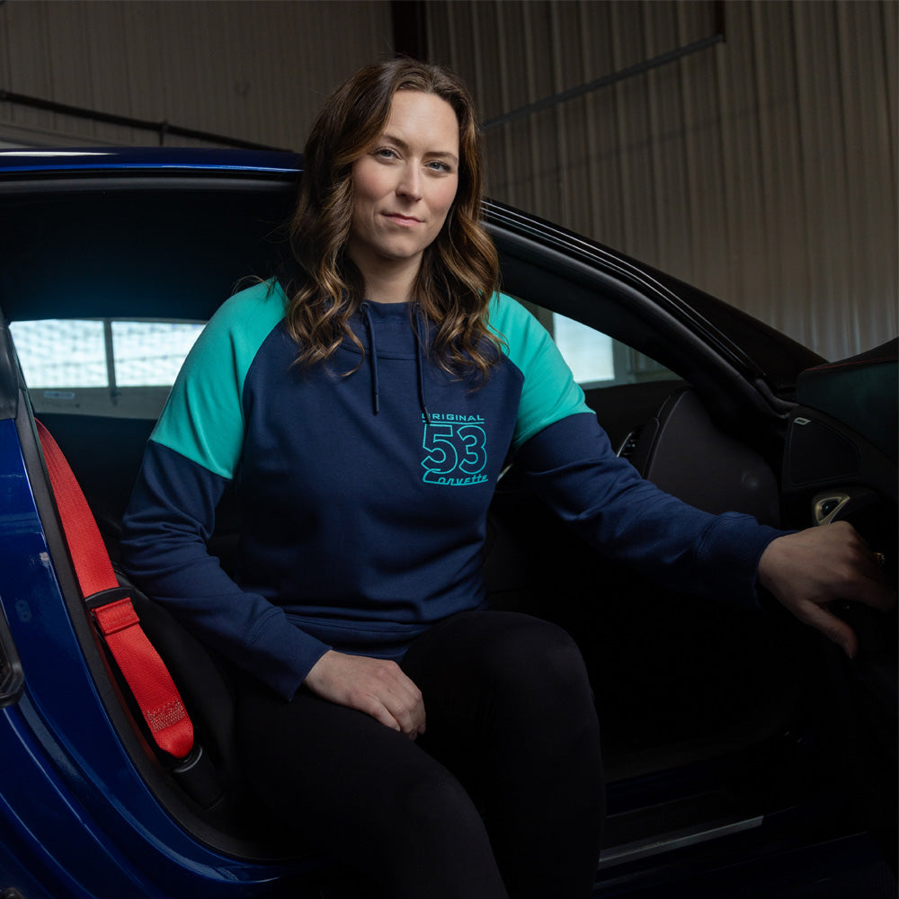 Woman sitting in a blue Corvette wearing the Corvette Original 53 Colorblock Hoodie