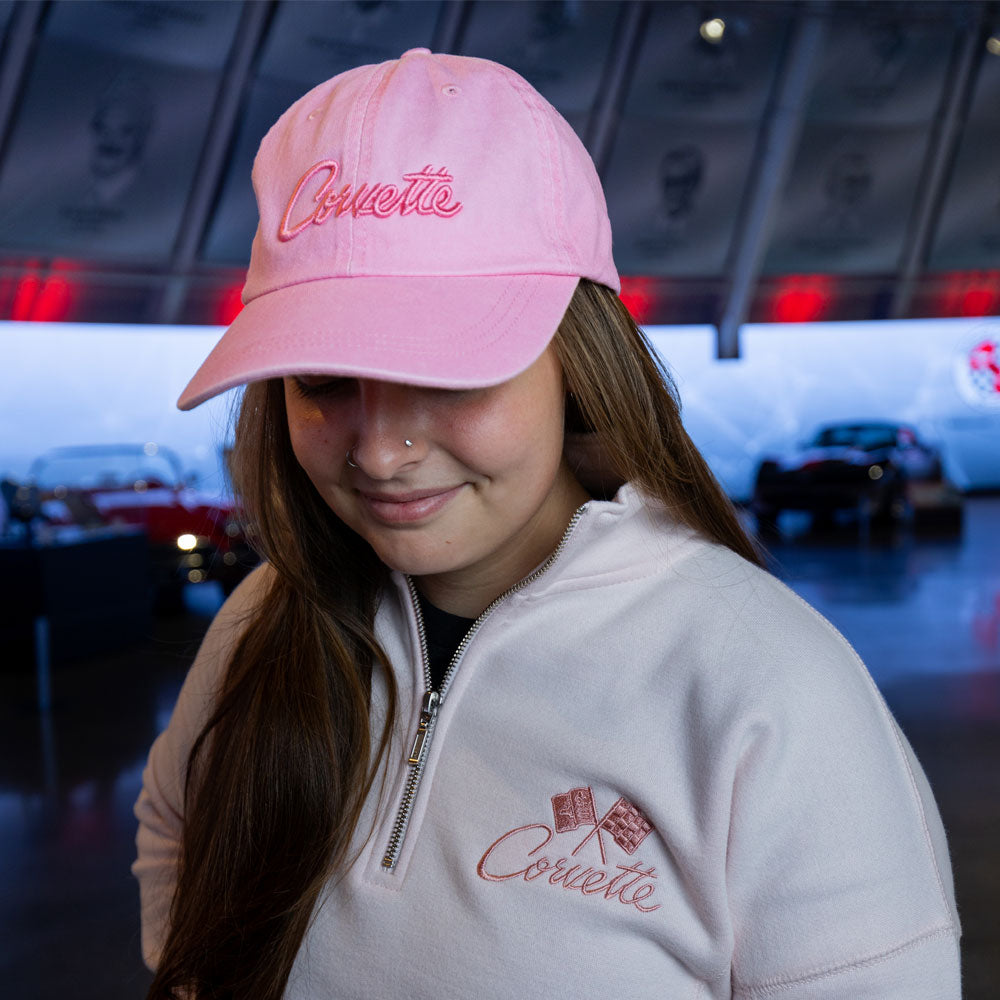 Woman wearing the Corvette Puff Embroidered Cotton Pink Twill Cap with the pink Corvette quarter-zip pullover