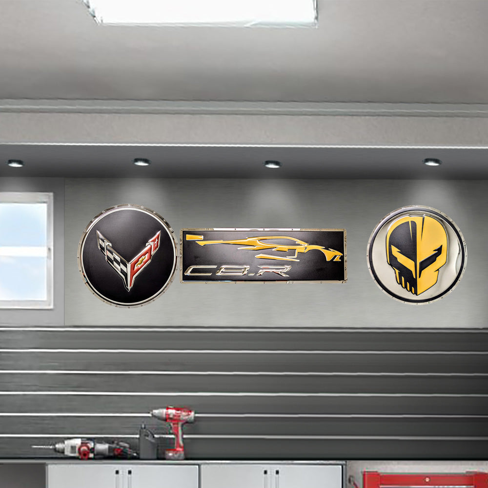 The Corvette C8R Gesture Stainless Steel Sign shown hanging up in a garage